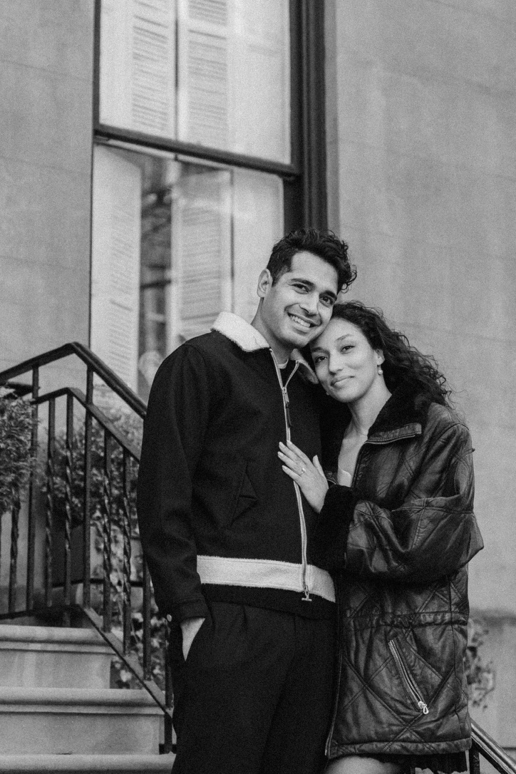 Arjun and Alexandra leaning together by a window