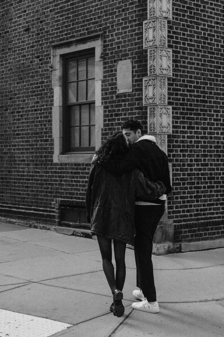 Arjun and Alexandra embracing on a city corner