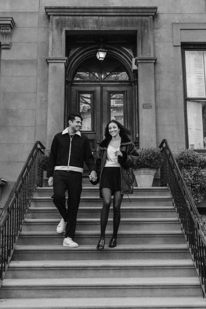 Arjun and Alexandra walking down a brownstone staircase